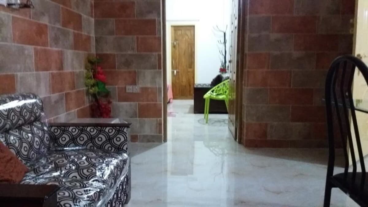The tiled interior hallway and lounge seating at Blue Bell Guest House