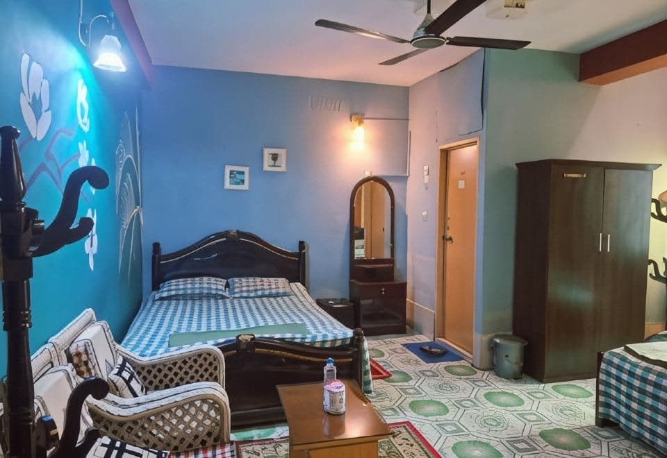 A double bedroom with a blue accent wall at Green Leaf Guest House