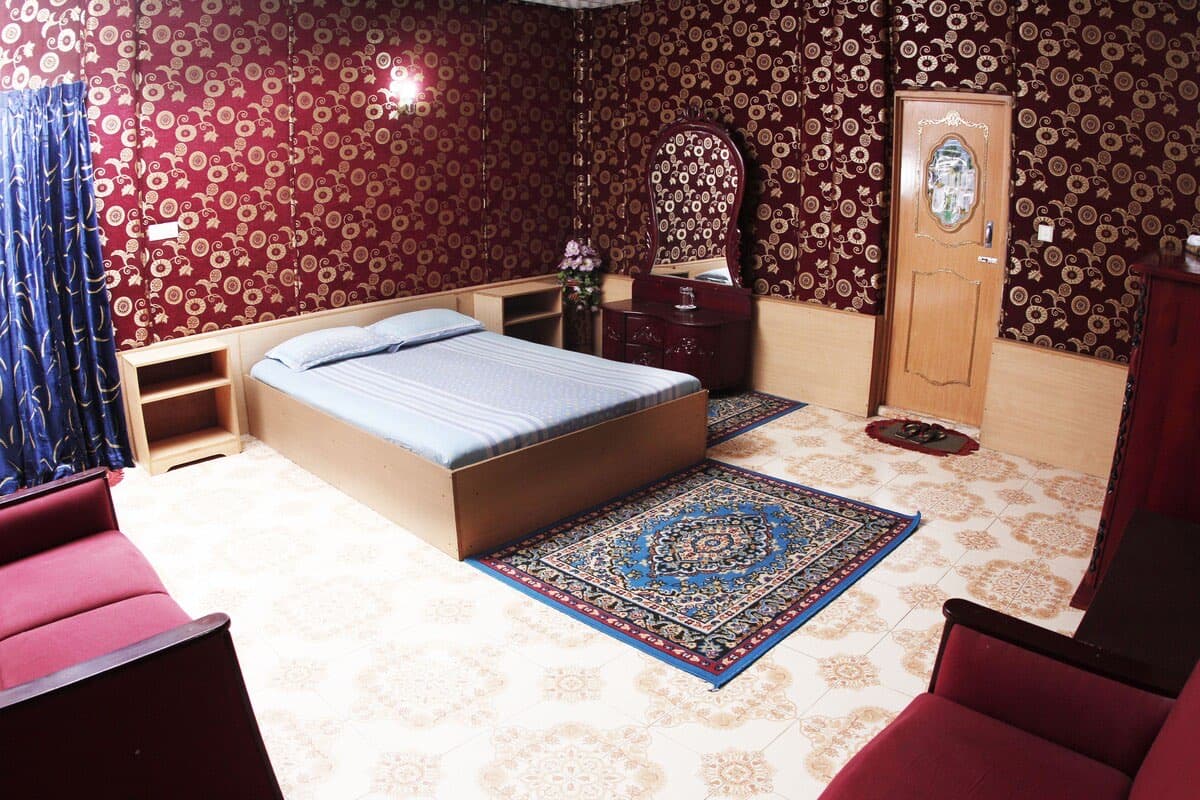 A deluxe double room with a patterned rug at Hill View Rest House