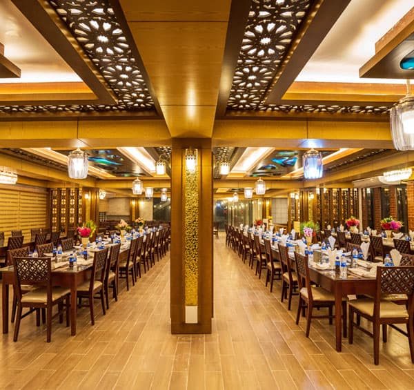 Lemon Garden's restaurant hall with carved wood ceiling panels and long rows of set dining tables